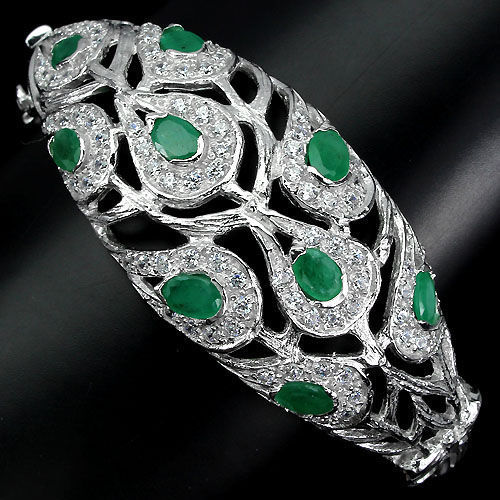 Floral cuff bracelet set with emeralds and natural white topaz . Total 124.95 ct.